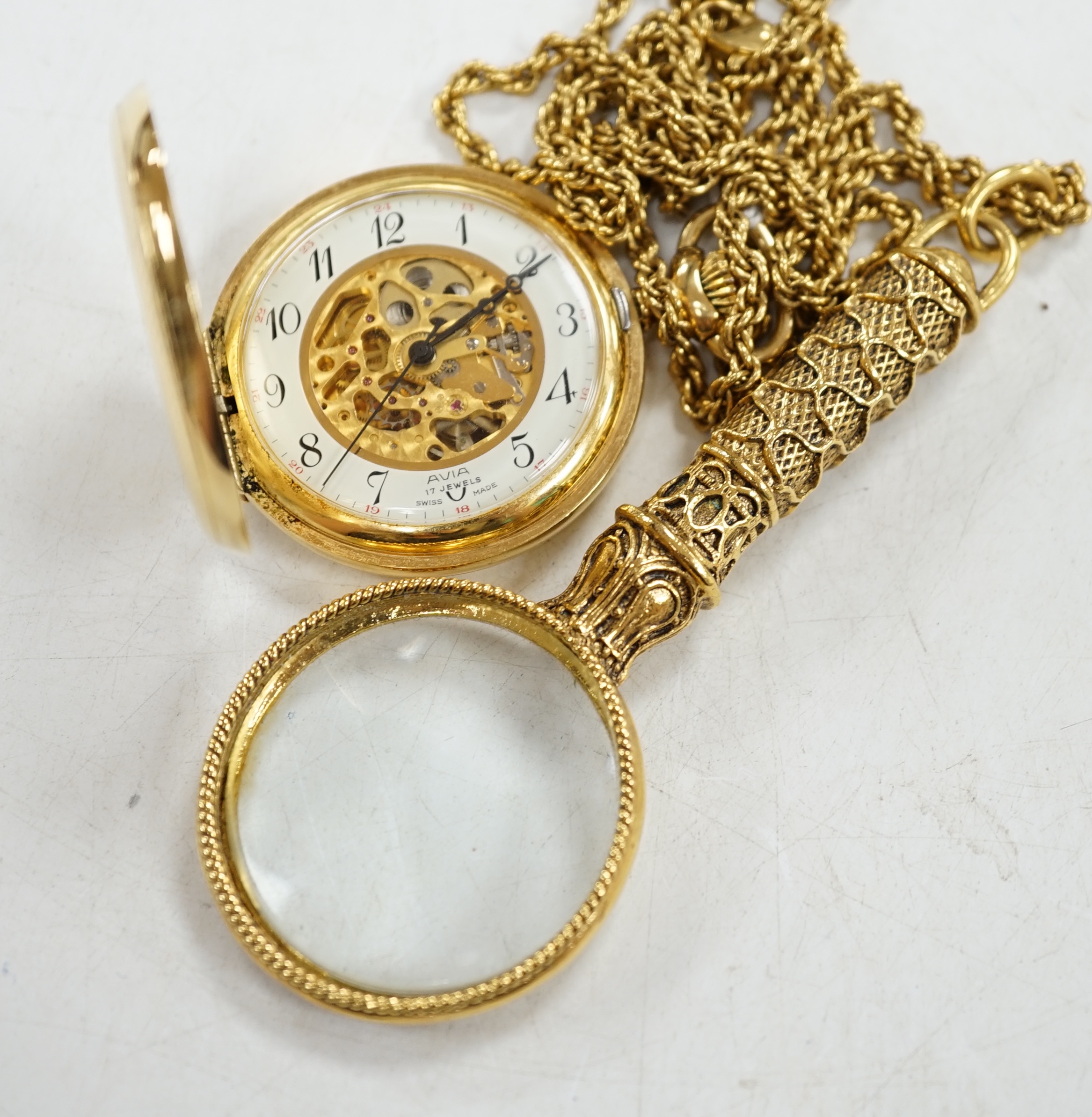 A gold plated Avia keyless pocket watch, on gilt chain with magnifying glass. Condition - fair